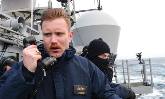 Lieutenant Commander Edward McGuinnis conning the USS Normandy (CG-60) during underway replenishment.